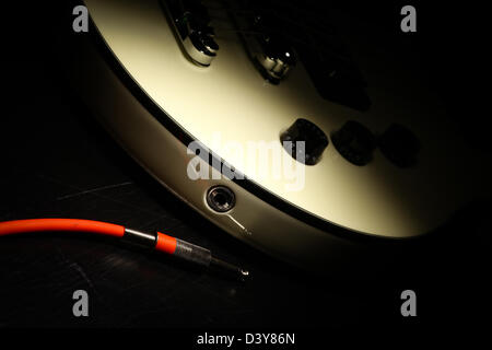 Dettagli su una chitarra elettrica e un cavo rosso Foto Stock