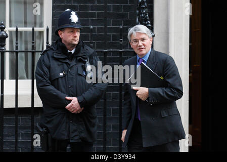 MP conservatore Andrew Mitchell passa da un funzionario di polizia come egli lascia il numero 10 di Downing Street a Londra il 23 marzo 2011. Foto Stock