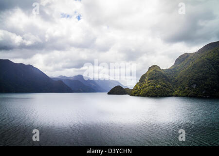 Sun streaming attraverso le nubi sul spectular Milford Sound, Isola del Sud, Nuova Zelanda Foto Stock