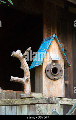 Un rustico birdhouse con tetto blu Foto Stock