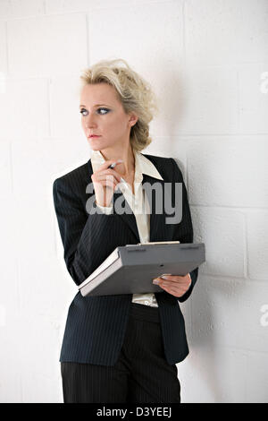 Business donna in tuta contro uno sfondo chiaro con una varietà di espressioni. Foto Stock