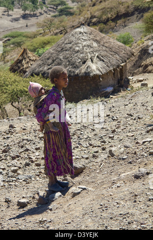 Ragazza locale con il bambino sul ciglio della strada in nord Africa Etiopia Foto Stock