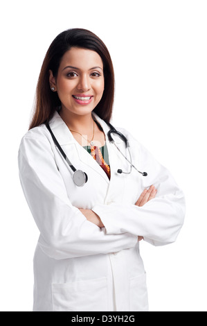 Medico donna in piedi con le braccia incrociate e sorridente Foto Stock