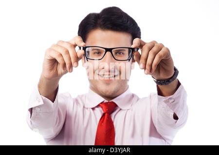 Ritratto di un imprenditore tenendo occhiali e sorridente Foto Stock