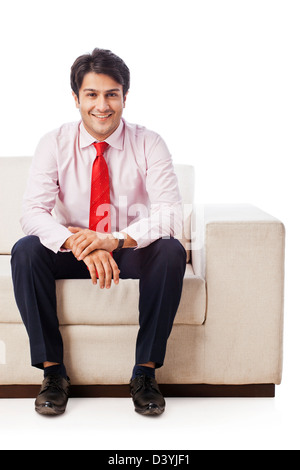 Ritratto di un imprenditore seduto su un divano e sorridente Foto Stock