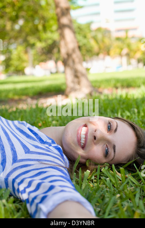 Donna sdraiata su erba, Miami Beach, Florida, Stati Uniti d'America Foto Stock
