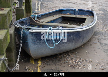 Piccola barca a terra collegato da una catena, parcheggiato di fronte a doppia linea gialla della segnaletica stradale, east twickenham, middlesex, Inghilterra Foto Stock