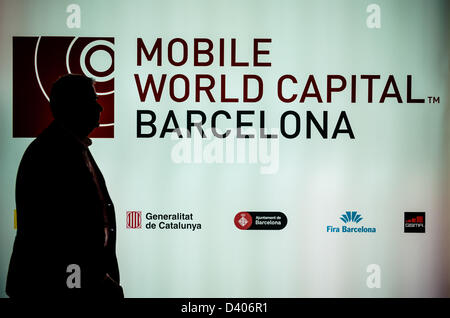 Barcellona, Spagna. 27 Febbraio 2013: Un partecipante del Mobile World Congress 2013 passa una parete illuminata. Foto Stock