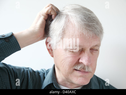 Senior uomo con prurito cuoio capelluto Foto Stock