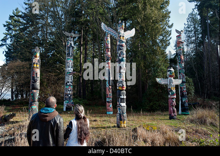 Giovane guardando totem poles a Stanley Park. Foto Stock