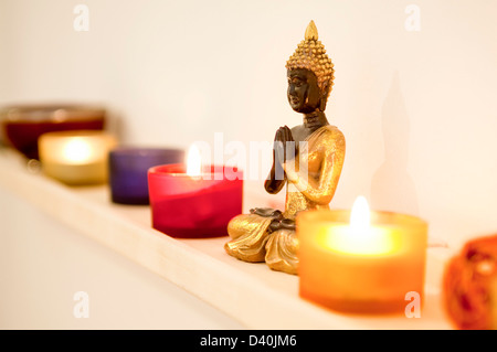 Golden statua del Buddha con candele Foto Stock