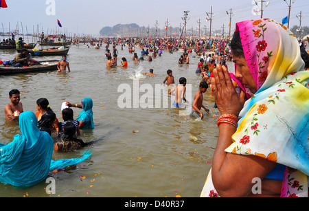 Un indù devoto prega dopo aver tenuto un santo tuffo presso la banca di Sangam confluenza del fiume Ganga, Yamnuna e mitico Saraswati. Foto Stock