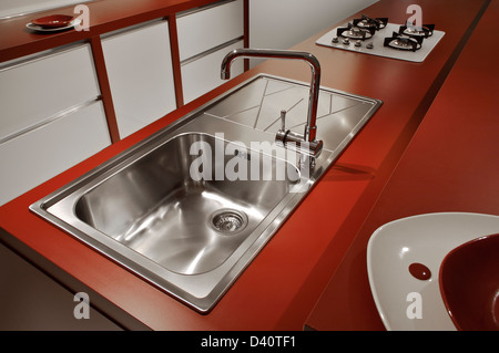 Cucina contemporanea in un rosso brillante dissipatore metallico con acqua del rubinetto Foto Stock