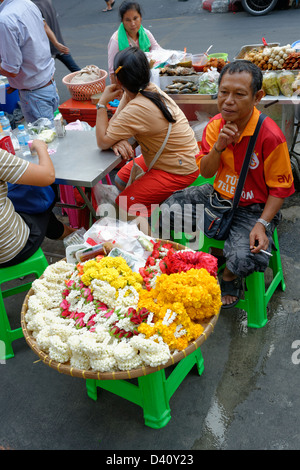 Uomo che vendono fiori, fiori venditore street trader a Bangkok, in Thailandia Foto Stock