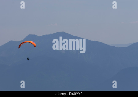 Parapendio sopra il paesaggio della Carinzia con le nuvole e le Alpi Foto Stock