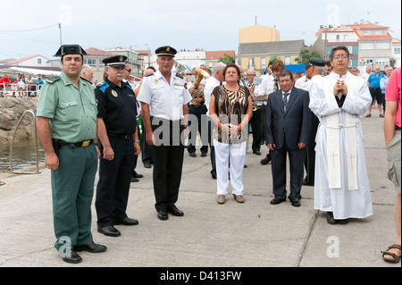 Dignitari locali che frequentano cerimonia per onorare i pescatori locali perso in mare, Corrubedo, Rias Baixas, Galizia, Spagna Foto Stock