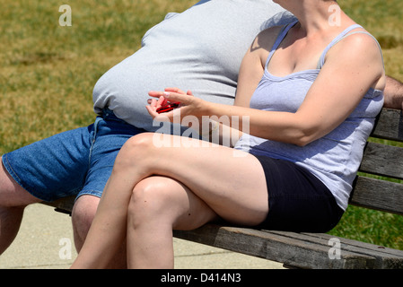 Il sovrappeso obesi uomo si siede con la moglie su un banco di lavoro Foto Stock