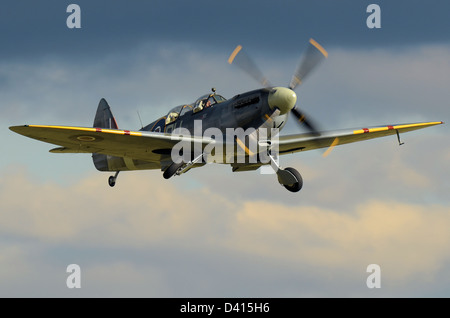 L'aereo da caccia Supermarine Spitfire MkIXT (Mark 9 trainer) a due posti decolla con Richard Grace ai comandi in un cielo tempestoso Foto Stock