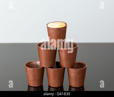 Pila di cioccolato bicchierini nella piramide con Irish cream versata in alto Foto Stock