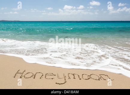 Luna di Miele parole scritte nella sabbia sulla spiaggia da mare in San Tommaso, dei Caraibi Foto Stock