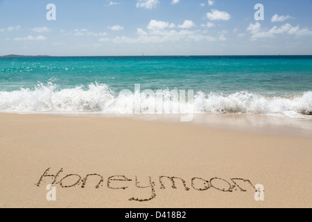 Luna di Miele parole scritte nella sabbia sulla spiaggia dal mare di San Tommaso Foto Stock