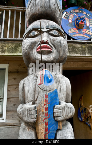 Parte di un totem scolpito nella tradizione Nuxalk nel grande orso nella foresta pluviale, nella città di Bella Coola, British Columbia, Canada. Foto Stock