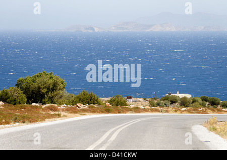 Naxos. Le Cicladi. La Grecia. Vista di un solitario autostrada con le acque blu del Mare Egeo in background. Foto Stock