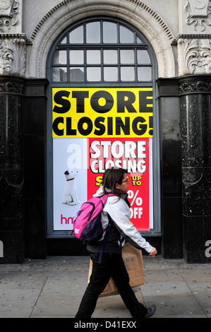 Una donna cammina passato un HMV store con con un segno a leggere 'store chiusura'. Piccadilly, Londra. Foto Stock