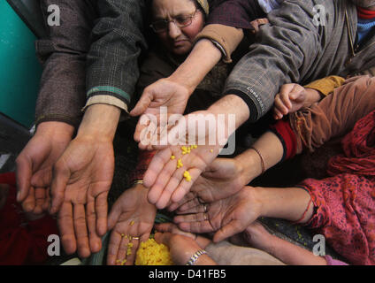 Srinagar Kashmir, India. 1 marzo 2013. Musulmani del Kashmir tendere le loro armi per ricevere il beato dolci al di fuori del santuario di Syed Abdul Qadir Jeelani (R.UN) comunemente noto come Gousul Azam Dastageer, per l anniversario della sua morte al suo Santuario a Srinagar. Centinaia di devoti assiepati al santuario per contrassegnare la fine di 19-giorno del festival e 815th anniversario della morte di Jeelani la cui tomba si trova a Bagdad in Iraq. Credito: ZUMA Press, Inc. / Alamy Live News Foto Stock