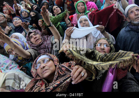 Srinagar Kashmir, India. 1 marzo 2013. Kashmir donne musulmane alzare le loro mani come pregano al di fuori del santuario di Syed Abdul Qadir Jeelani (R.UN) comunemente noto come Gousul Azam Dastageer, per l anniversario della sua morte al suo Santuario a Srinagar. Centinaia di devoti assiepati al santuario per contrassegnare la fine di 19-giorno del festival e 815th anniversario della morte di Jeelani la cui tomba si trova a Bagdad in Iraq. Credito: ZUMA Press, Inc. / Alamy Live News Foto Stock