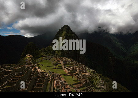 Machu Picchu rovine Inca di Huayna Picchu mountain in background scendendo nuvole sopra la valle sacra Foto Stock