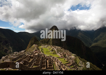 Machu Picchu rovine Inca di Huayna Picchu mountain in background scendendo nuvole sopra la valle sacra Foto Stock