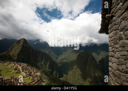 Machu Picchu rovine Inca di Huayna Picchu mountain in background scendendo nuvole sopra la valle sacra Foto Stock