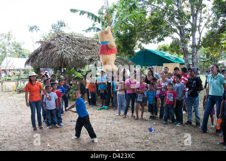 Un ragazzo panamense cercando di rompere una pinata al Festival de la Naranja. Foto Stock