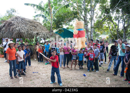 Un ragazzo panamense cercando di rompere una pinata al Festival de la Naranja. Foto Stock