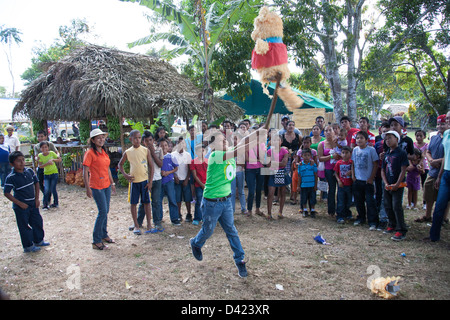 Un ragazzo panamense cercando di rompere una pinata al Festival de la Naranja. Foto Stock