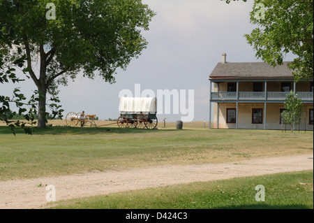 Cielo blu verde erba visualizza white baldacchino Prairie Schooner carro permanente per il lato caserma di cavalleria, Fort Laramie, Wyoming USA Foto Stock