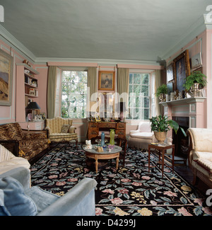 Motivi floreali tappeto nero in blu pallido al piano superiore un soggiorno con circolare tabella di caffè Foto Stock