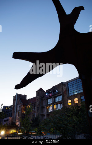 Berlino, Germania, scultura davanti al retro del Kunsthaus Tacheles di sera Foto Stock