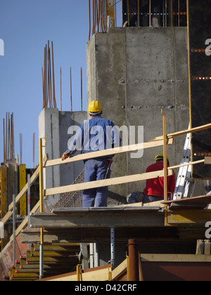 Costruzione i lavoratori che operano sulla piattaforma di costruzione con cassaforma Foto Stock