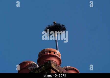 Spazzacamini spazzola bloccata al di fuori di un comignolo Foto Stock