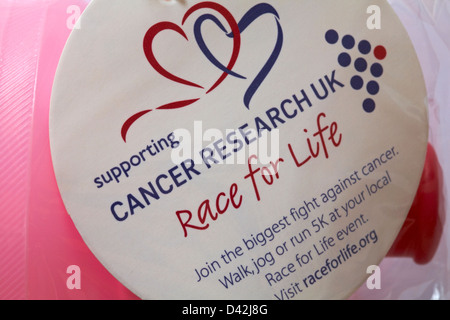 Il supporto di Cancer Research UK Race per la vita adesivo sulla bottiglia di bevanda Foto Stock