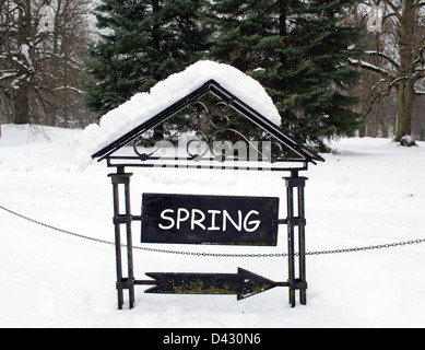 retro steel arrow show direction with blank board place for text covered with winter snow. Foto Stock