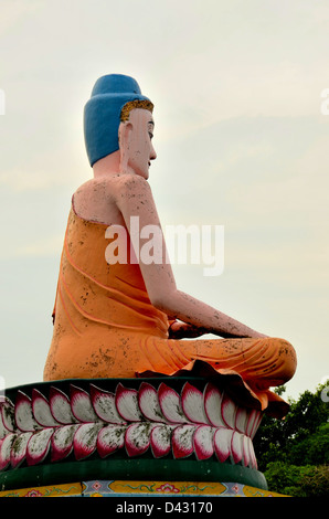La meditazione Buddha nella posizione del loto seduto su petali di fiori Foto Stock