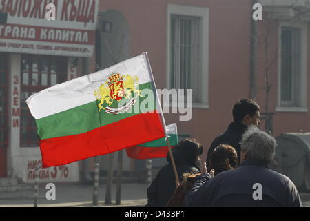 Sofia, Bulgaria; 03/03/2012. I manifestanti sventola una bandiera bulgara durante la marcia di protesta attraverso il centro di Sofia. Foto Stock