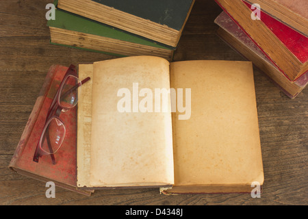 Vecchio libro aperto con le pagine bianche su sfondo di legno. Foto Stock