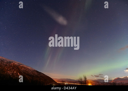 Debole bianco e verde di striature di Northern lights aurora boreale sul fiordo vicino a Tromso in Norvegia del nord europa Foto Stock