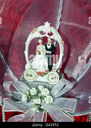 Il rossore della sposa e lo sposo figure decorate con rose per la parte superiore di una torta di nozze visualizzato nella finestra del negozio Oaxaca Messico Foto Stock