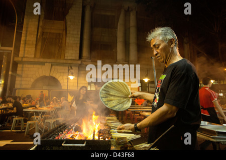 SINGAPORE - 2013: Saté Street al Lau Pa Sat hawker market alimentare. Saté chef appassionati il suo grill barbecue. Foto Stock