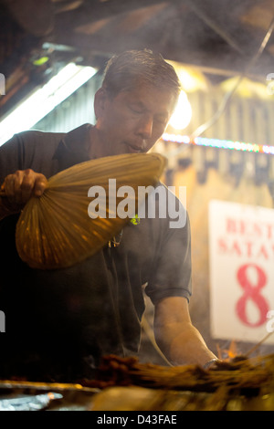 SINGAPORE - 2013: Saté Street al Lau Pa Sat hawker market alimentare. Saté chef appassionati il suo grill barbecue. Foto Stock